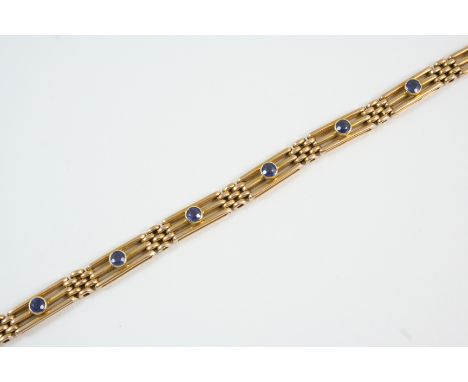 A 15CT. GOLD GATE LINK BRACELET each link set with a circular-cut sapphire, with concealed clasp, 18.5cm. long, 16 grams.