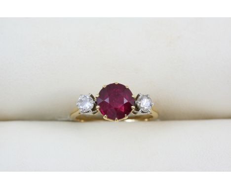 A RUBY AND DIAMOND THREE STONE RING the circular-cut ruby is set with two circular-cut diamonds, in gold. Size J.