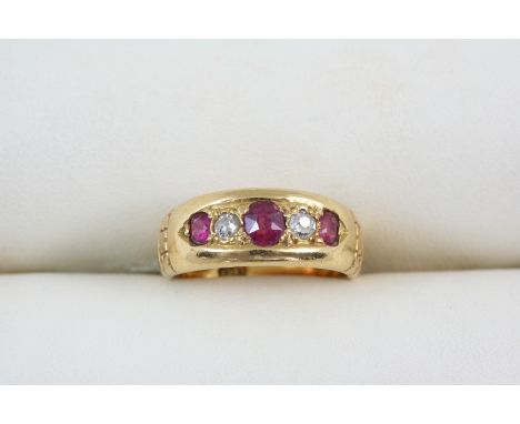 A RUBY AND DIAMOND FIVE STONE RING set with three oval-shaped rubies and two circular-cut diamonds, in 18ct. gold. Size K.