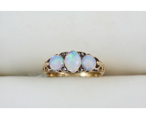 AN OPAL AND DIAMOND RING set with an oval cabochon opal and two circular cabochon opals, with four rose-cut diamonds, in 18ct