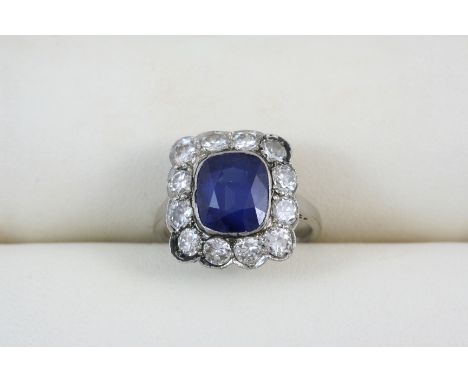 A SAPPHIRE AND DIAMOND CLUSTER RING the oval-shaped sapphire is set within a surround of twelve old brilliant-cut diamonds. S