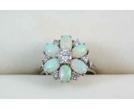 AN OPAL AND DIAMOND CLUSTER RING of flower head form, set with oval cabochon opals and circular-cut diamonds. Size N.