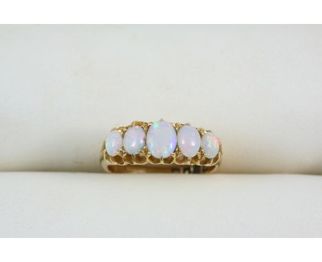 AN OPAL FIVE STONE RING set with five graduated oval cabochon opals, in 18ct. gold. Size L.