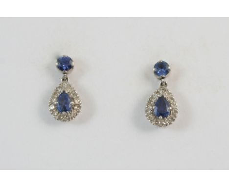 A PAIR OF SAPPHIRE AND DIAMOND DROP EARRINGS the pear-shaped sapphires are set within a surround of circular-cut diamonds, wi