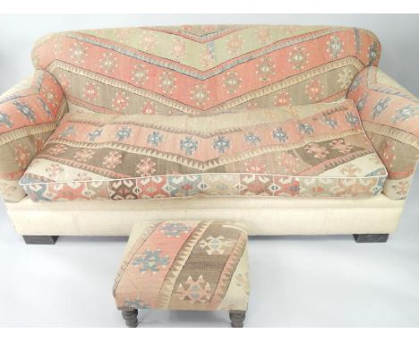 A three seater Kilim sofa, with loose cushions, 191cm long, together with a matching foot stool, raised on turned legs, (2).