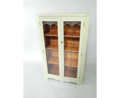 An eau de nil painted hardwood display cabinet, with a pair of glass doors enclosing three shelves, raised on bracket feet, 7
