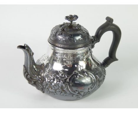 A Victorian silver tea pot, of pear form with embossed floral and rococo scroll decoration, reserve vignette with engraved cr