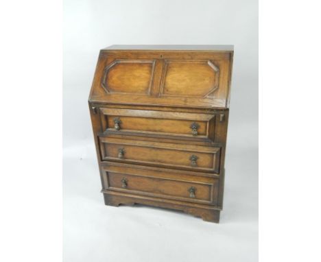 An oak and walnut bureau, the fall flap enclosing drawers and recesses, over three long drawers raised on bracket feet, 76.5c