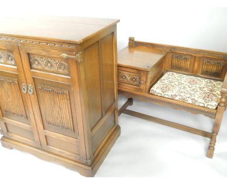 An Old Charm oak cabinet with linenfold panelled doors, raised on bracket feet, 87.5cm x 53.5cm x 101cm, and an oak telephone