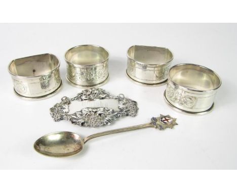 A silver whisky decanter label, Sheffield 1978, four napkin rings and a silver and enamel commemorative teaspoon, 2nd Bn Cold