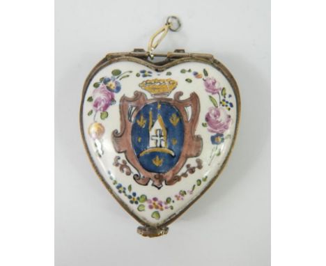 A French 19thC enamel heart shaped patch box and hinged cover, painted with a coat of arms within a floral surround, 5.5cm lo