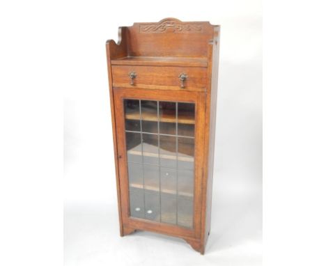 An Art Nouveau oak bookcase, the galleried top over a lead glazed door enclosing three shelves raised on bracket feet, 58.5cm