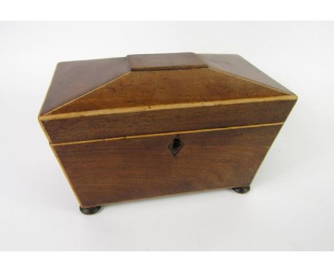 A Regency mahogany and boxwood line inlaid tea caddy, of sarcophagus twin compartment form, raised on bun feet, 20.5cm x 12cm