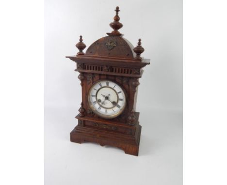 A Junghans oak cased mantel clock, white enamel dial with chapter ring bearing Roman numerals, eight day movement, coil strik