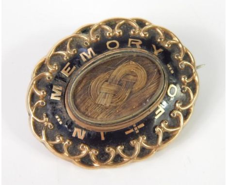 A Victorian memorial brooch, with black enamel design, inset central plaid hair, and inscribed 'in memory of', with inscripti