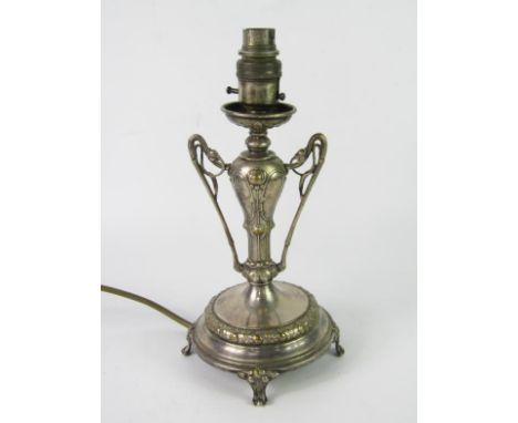 A WMF plated table lamp, of twin handled form embossed with flowers, raised on a circular base and four scroll feet, 28.5cm h