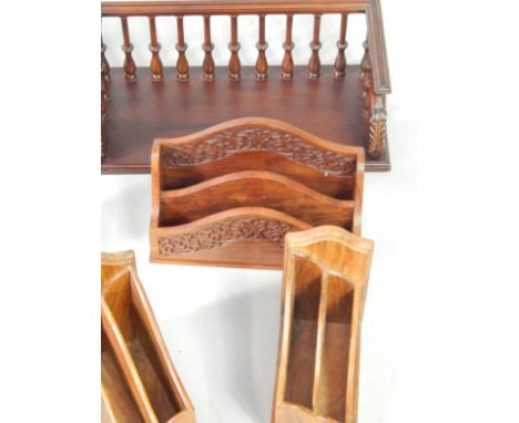 An Indian hardwood book trough with foliate carving, a galleried book shelf and four carved stationery racks, (6).