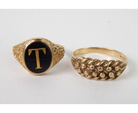 A 9ct gold keeper ring, size R/S, and a 9ct gold and black onyx signet ring, set with the letter T, size R, (2).