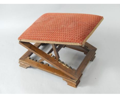 An early 20thC oak framed gout stool with upholstered seat, raised on ogee bracket feet.