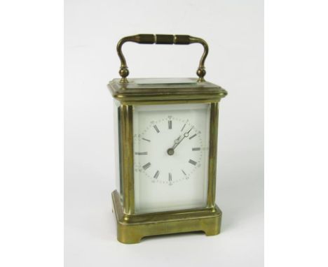 A brass carriage clock, enamel dial bearing Roman and Arabic numerals, with key, 9.5cm x 8cm x 15.5cm.