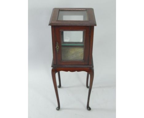 An Edwardian mahogany bijouterie cabinet, of square section, with a single glass shelf, raised on slender cabriole legs, 30.5