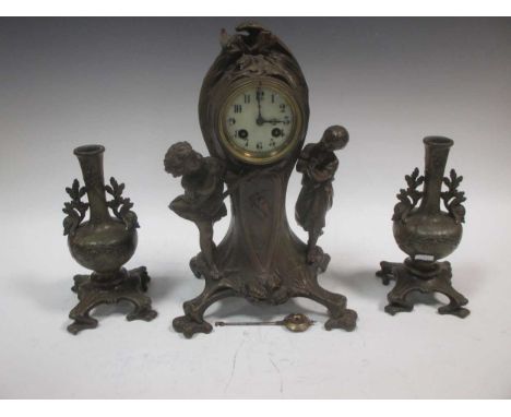 An Art Nouveau style three piece clock garniture, comprising of a figural mantel clock and a pair of vases (3)