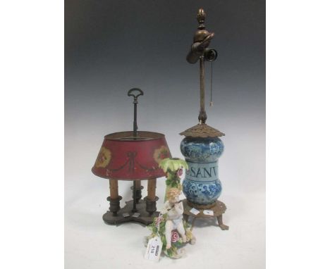 A lamp en bouillotte; a blue and white jar lamp; and a German cupid, (less his wings) candlestick (3)