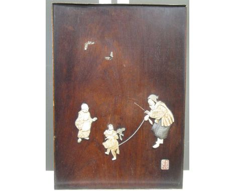 A Japanese wooden panel inlaid with ivory and mother of pearl depicting a boy watching a dancing monkey and its owner, 39.5 x