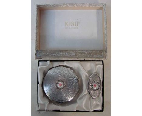 A Kigu ladies Powder Compact and Lipstick Holder, the compact of shaped circular form with engine turned surfaces, the top ce