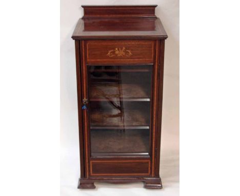 An Edwardian mahogany and inlaid Music Cabinet, the inlaid back rail on inlaid moulded edge top over inlaid single pane glaze