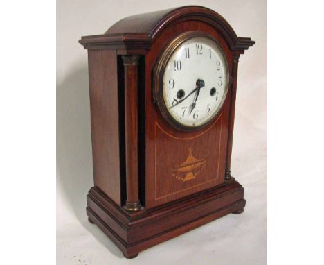 An Edwardian mahogany and inlaid cased Mantel Clock of break arch form with turned corner pilasters, the white enamel dial wi