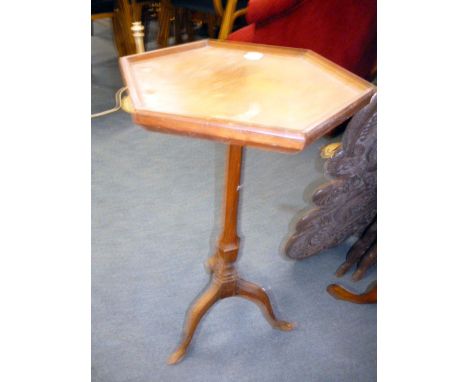 A walnut hexagonal table, having galleried top on tripod base