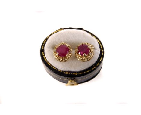 A pair of ruby and silver gilt stud earrings, the round cut rubies in four claw setting, mounted on silver gilt studs (2)