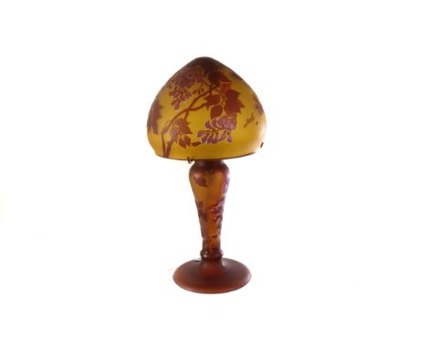 A Gallé style glass lamp and shade, the amber coloured lamp and shade with raised maroon leaf and foliate decoration, on wide