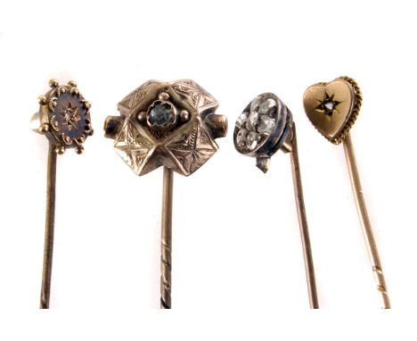 Four yellow metal and diamond stick pins, each of a different design witrh either single or multiple stone design (4)