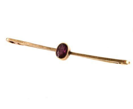 A 9ct gold and ruby stick pin/bar brooch, the oval cut ruby centrally mounted in rubbed over setting, approx 1.8g