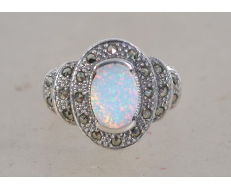 An Art Deco style ring set with a central opal and marcasite. Size N. Weight 5.5g. Marked 925.