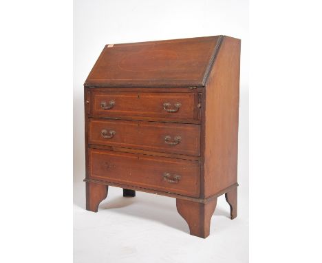 An Edwardian mahogany inlaid bureau writing desk. The fall front with appointed interior having a chest of drawers beneath, a