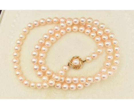 A CULTURED PEARL NECKLACE, a long string of cultured pearls, approximate pearl diameter 6.7mm, fitted with a yellow metal pea