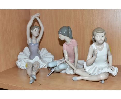 THREE CERAMIC SEATED BALLET FIGURES comprising a Lladro 'Shelley/Pink Ballerina' figure marked 1357 to the base, designed by 