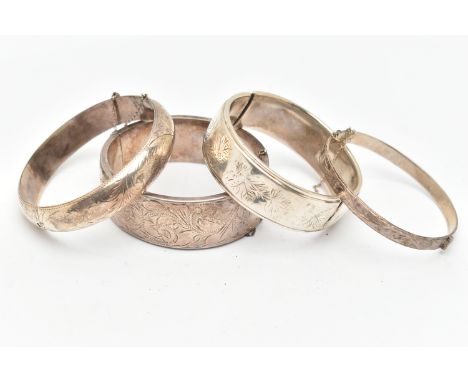 THREE SILVER BANGLES AND A WHITE METAL BANGLE, a wide hinged bangle, etched with scrolling acanthus detail, a thin hinged ban