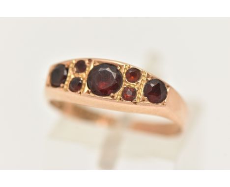 A LATE VICTORIAN 15CT GOLD GARNET RING, set with seven circular cut garnets, to a polished band, hallmarked 15ct Birmingham 1