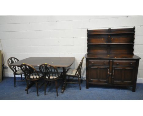 LUCIAN ERCOLANI, A MID CENTURY ERCOL DARK ELM AND BEECH RECTANGULAR DINING TABLE, raised on trestle legs, united by a stretch