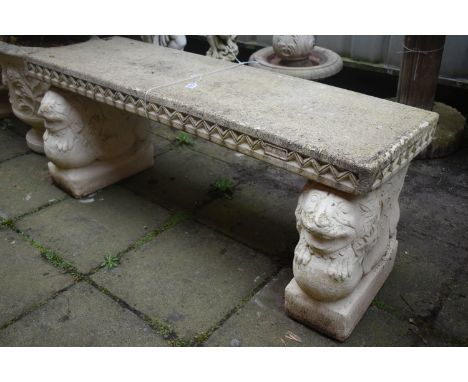 A WEATHERED PAINTED COMPOSITE GARDEN BENCH, on a pair of stands depicting lions on a ball, length 121cm x depth 40cm x height