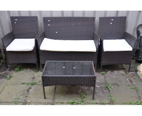 AN UNBRANDED FAUX RATTAN FOUR PIECE GARDEN SET, comprising a two seater sofa, length 104cm, pair of armchairs and a glass top