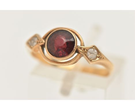 A 22CT GOLD GEM SET RING, set with a central circular cut red stone assessed as garnet, collet set within an open surround, f