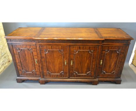 A 20th Century Mahogany Break Front Sideboard, the crossbanded and moulded top above a blind fretwork frieze and four doors r