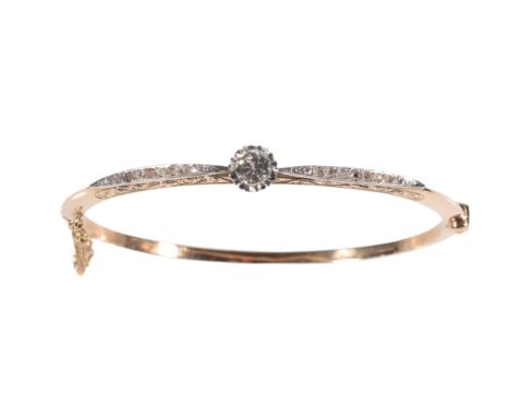 A DIAMOND HALF SET HINGED BANGLE the centre diamond c.0.40ct illusion set flanked either side with miligrain diamonds, on an 