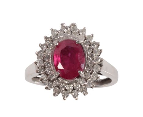 A SYNTHETIC RUBY AND DIAMOND CLUSTER RING the oval-cut ruby c.7mm x 6mm, within a double border of round-cut diamonds, on a 1