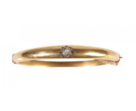 A GOLD AND DIAMOND BANGLE set with a solitaire round-cut diamond, the clasp stamped "15", approx 8grams total weight